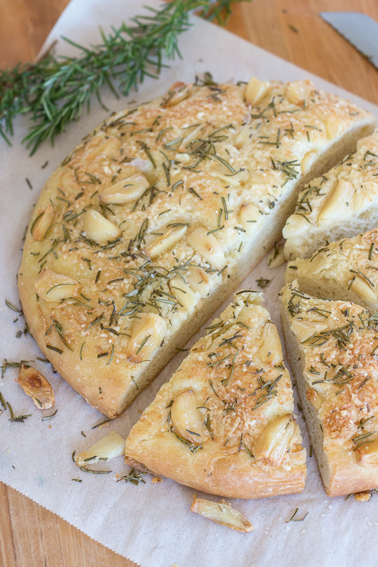 Plenty of roasted garlic, fresh rosemary, and Parmesan cheese make this garlic and rosemary focaccia super flavorful. It's perfect with a bowl of soup, alongside a hearty salad, or served with dinner instead of traditional rolls.