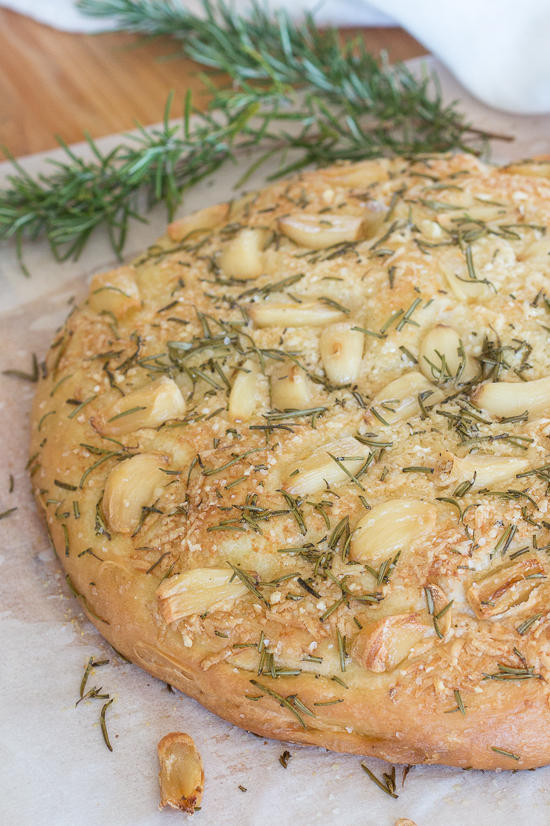 Plenty of roasted garlic, fresh rosemary, and Parmesan cheese make this garlic and rosemary focaccia super flavorful. It's perfect with a bowl of soup, alongside a hearty salad, or served with dinner instead of traditional rolls.