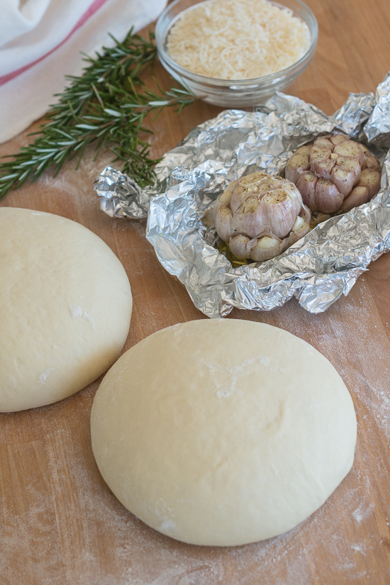 Plenty of roasted garlic, fresh rosemary, and Parmesan cheese make this garlic and rosemary focaccia super flavorful. It's perfect with a bowl of soup, alongside a hearty salad, or served with dinner instead of traditional rolls.