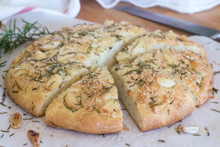 Plenty of roasted garlic, fresh rosemary, and Parmesan cheese make this garlic and rosemary focaccia super flavorful. It's perfect with a bowl of soup, alongside a hearty salad, or served with dinner instead of traditional rolls.