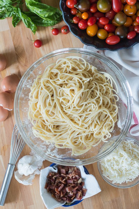 With bacon and cheese tucked in the center, this savory noodle cake tastes delicious topped with fresh summer tomatoes. This simple, flavorful recipe is easy to prepare. It's a great way to use up leftover spaghetti, too!