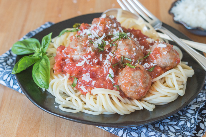 Ladled over spaghetti, these classic meatballs with simple tomato sauce epitomize hearty comfort food. Serve a crowd with this generous recipe or hoard the leftovers for easy meal planning.