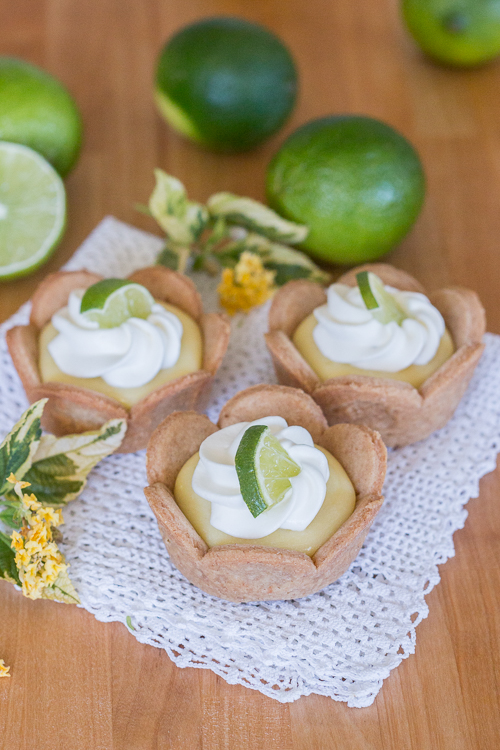 Homemade graham cracker cups filled with sweet, tangy lime curd come together in adorable little lime tarts. Simple to serve, these eat-by-hand treats make a perfect party dessert.