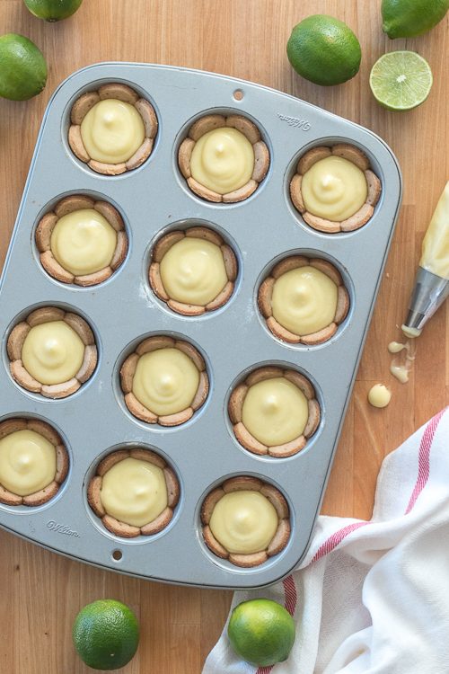 Homemade graham cracker cups filled with sweet, tangy lime curd come together in adorable little lime tarts. Simple to serve, these eat-by-hand treats make a perfect party dessert.