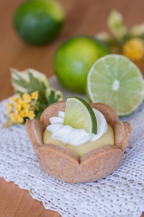 Homemade graham cracker cups filled with sweet, tangy lime curd come together in adorable little lime tarts. Simple to serve, these eat-by-hand treats make a perfect party dessert.