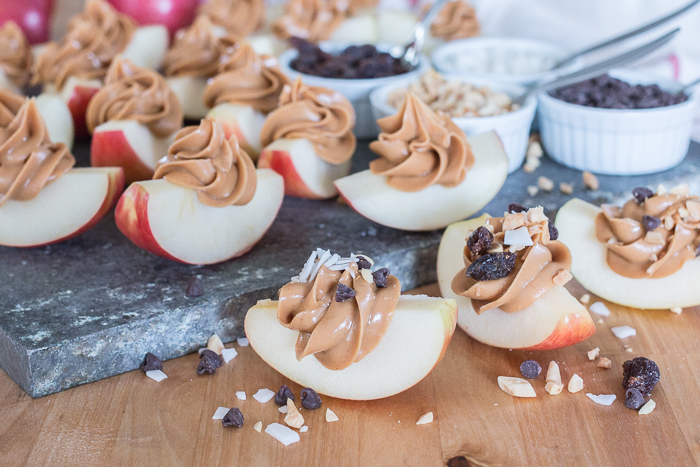 Dress up a simple, wholesome snack of Peanut Butter Apple Slices by piping creamy peanut butter in small spirals atop crisp, tart apples. Sprinkling toppings like mini chocolate chips, toasted coconut, or raisins over these apple-tizers adds to the fun of this easy, healthy snack. 