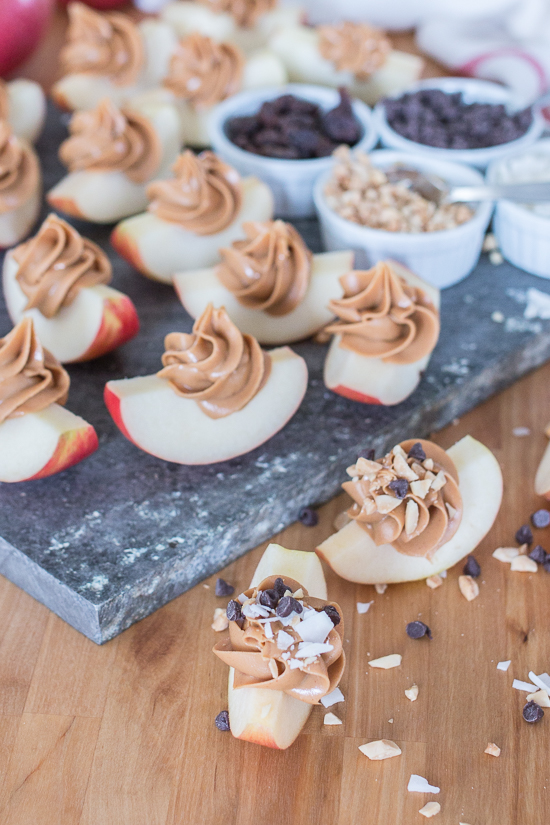 Dress up a simple, wholesome snack of Peanut Butter Apple Slices by piping creamy peanut butter in small spirals atop crisp, tart apples. Sprinkling toppings like mini chocolate chips, toasted coconut, or raisins over these apple-tizers adds to the fun of this easy, healthy snack. 