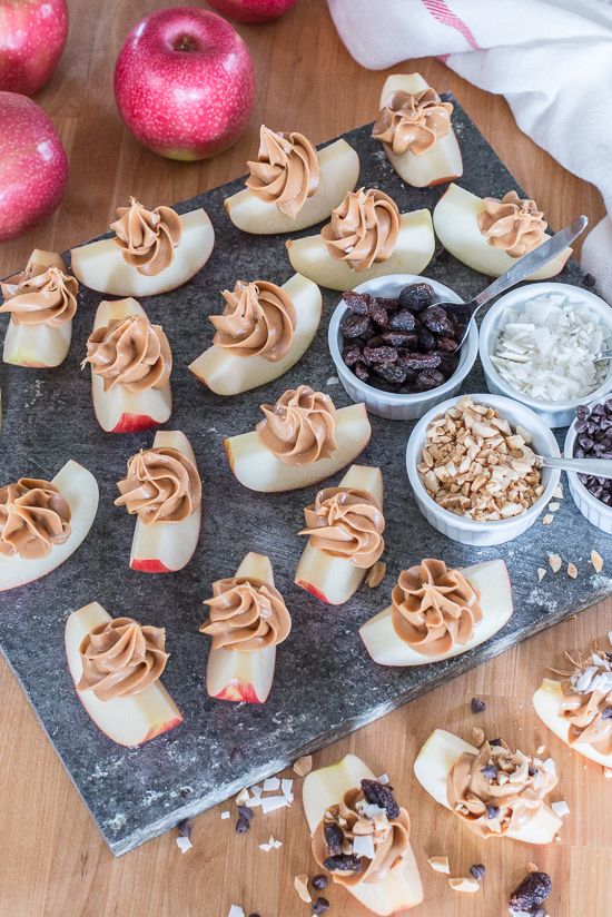 Dress up a simple, wholesome snack of Peanut Butter Apple Slices by piping creamy peanut butter in small spirals atop crisp, tart apples. Sprinkling toppings like mini chocolate chips, toasted coconut, or raisins over these apple-tizers adds to the fun of this easy, healthy snack. 