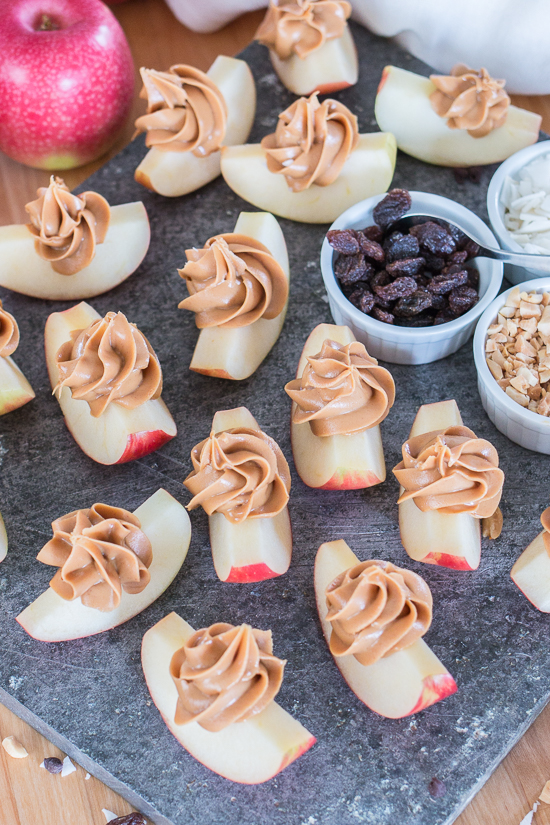 Dress up a simple, wholesome snack of Peanut Butter Apple Slices by piping creamy peanut butter in small spirals atop crisp, tart apples. Sprinkling toppings like mini chocolate chips, toasted coconut, or raisins over these apple-tizers adds to the fun of this easy, healthy snack. 