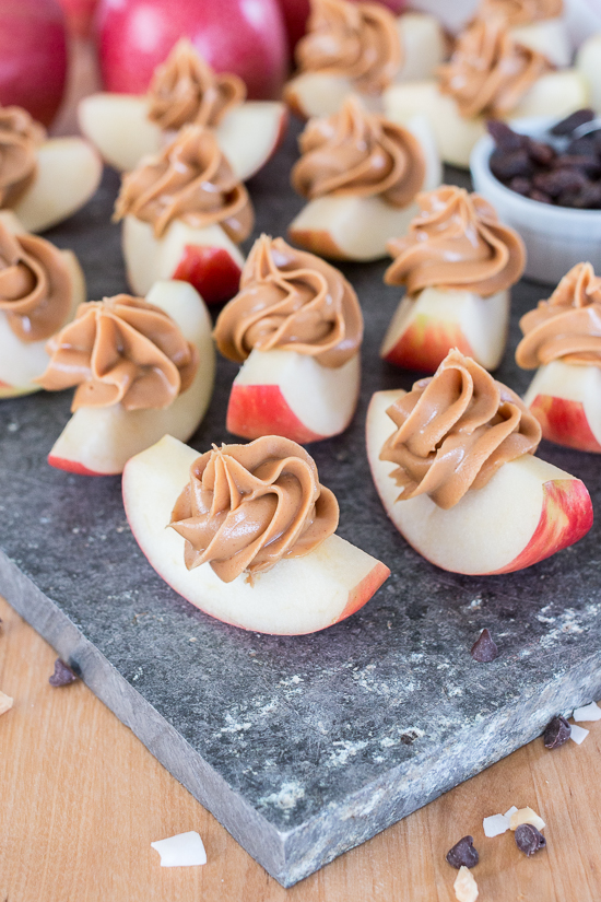 Dress up a simple, wholesome snack of Peanut Butter Apple Slices by piping creamy peanut butter in small spirals atop crisp, tart apples. Sprinkling toppings like mini chocolate chips, toasted coconut, or raisins over these apple-tizers adds to the fun of this easy, healthy snack. 