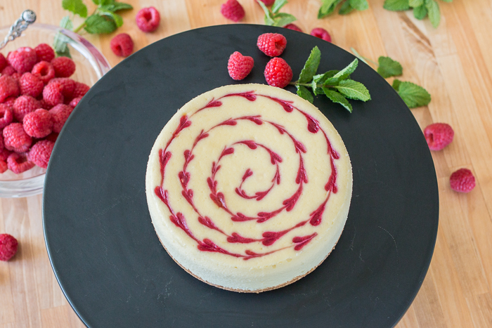 Smooth and indulgent, this Vanilla Raspberry Cheesecake hides a surprise layer of tart raspberry filling in the center. Decorative heart embellishments add flair to this petite, delicious cheesecake. 