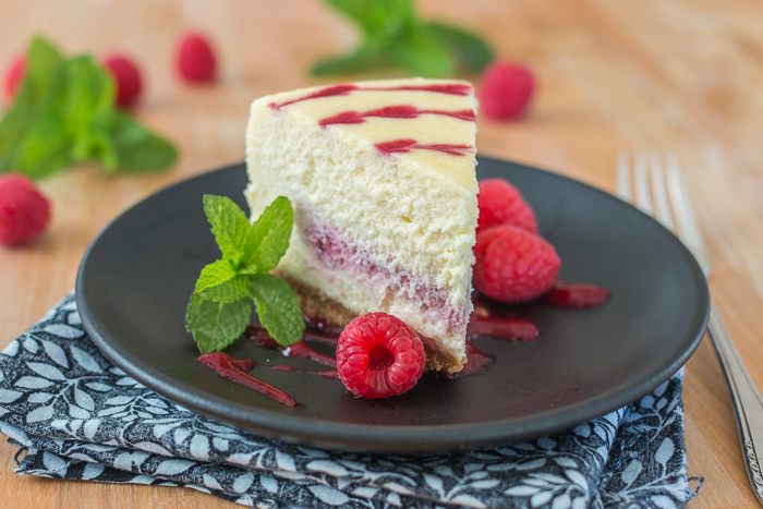 Smooth and indulgent, this Vanilla Raspberry Cheesecake hides a surprise layer of tart raspberry filling in the center. Decorative heart embellishments add flair to this petite, delicious cheesecake. 