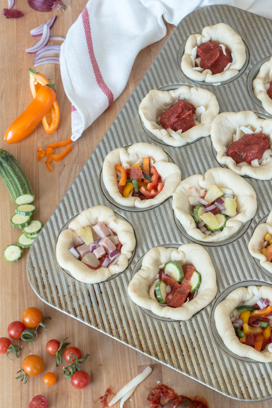 These Mini Deep Dish Pizzas deliver big flavor in adorable muffin-sized packaging. Loaded with mozzarella cheese, flavorful tomato sauce, and tasty fillings, these petite pizzas make a satisfying, easy-to-prepare meal. 