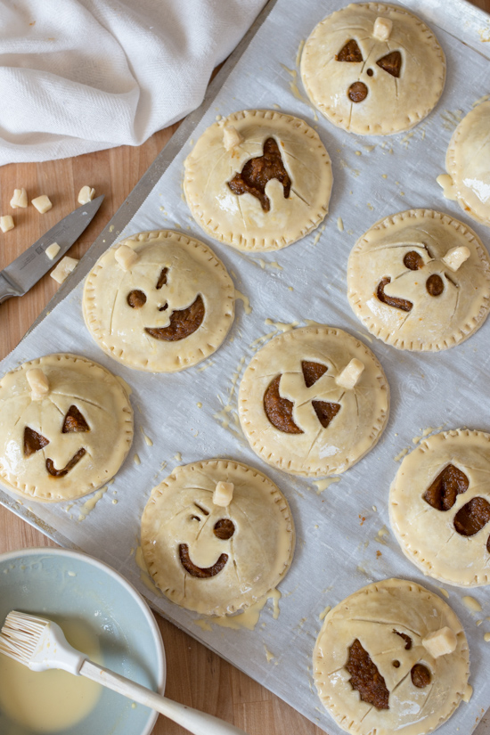 Perfect for Halloween, these adorable Jack-O'-Lantern Pumpkin Hand Pies feature a velvety-smooth pumpkin filling tucked between layers of rich, flaky pastry. 