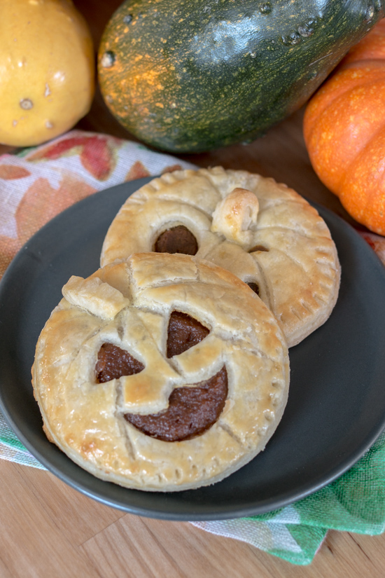 Perfect for Halloween, these adorable Jack-O'-Lantern Pumpkin Hand Pies feature a velvety-smooth pumpkin filling tucked between layers of rich, flaky pastry. 