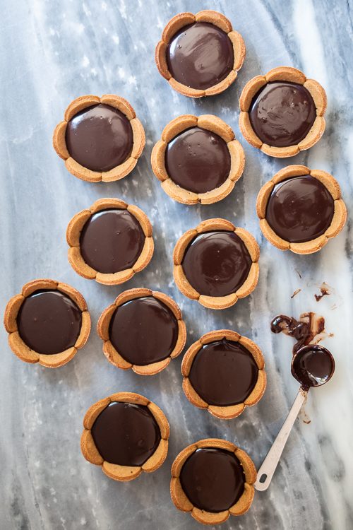 Spicy gingerbread cookie crusts provide a bold, flavorful backdrop for sweet caramel and rich, smooth ganache in these Mini Salted Caramel-Chocolate Tarts. 