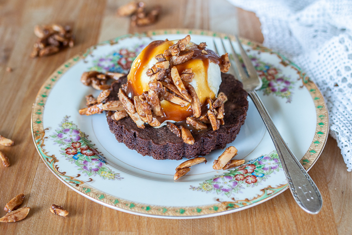 These fudgy, hint-of-cinnamon Brownie Tartlets taste incredible with vanilla ice cream, warm caramel sauce, and a sprinkling of crunchy almonds.