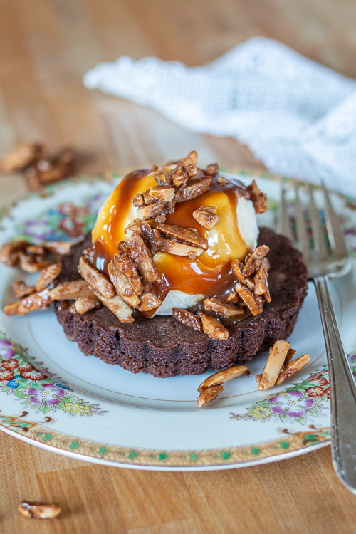These fudgy, hint-of-cinnamon Brownie Tartlets taste incredible with vanilla ice cream, warm caramel sauce, and a sprinkling of crunchy almonds.