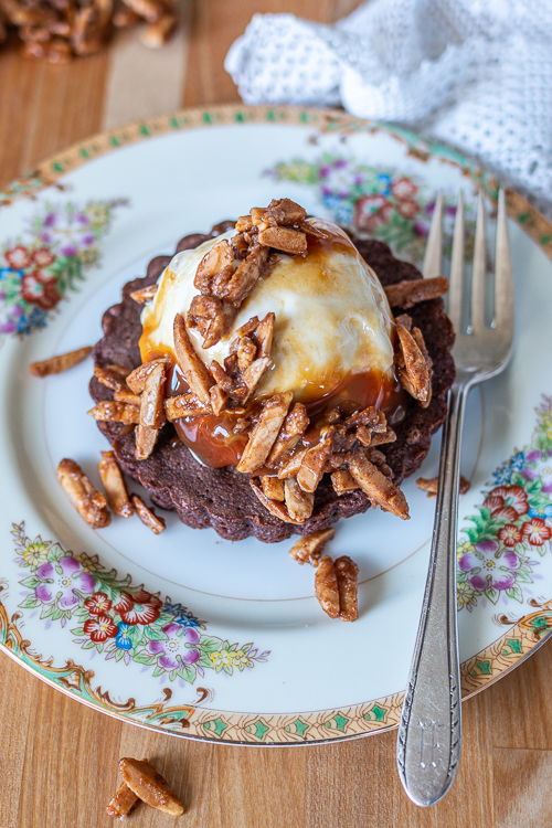 These fudgy, hint-of-cinnamon Brownie Tartlets taste incredible with vanilla ice cream, warm caramel sauce, and a sprinkling of crunchy almonds.