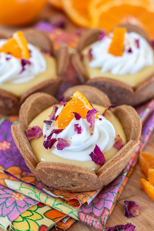 Mini Mandarin Tarts feature sweet, creamy mandarin curd layered into crisp gingerbread cookie cups.  The tangy citrus pairs so well with the gingerbread, delivering a bright, sunny flavor with a holiday twist.