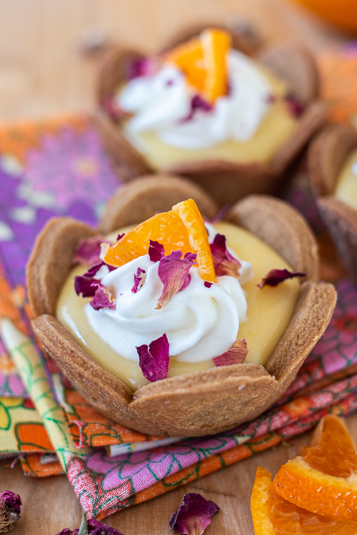 Mini Mandarin Tarts feature sweet, creamy mandarin curd layered into crisp gingerbread cookie cups.  The tangy citrus pairs so well with the gingerbread, delivering a bright, sunny flavor with a holiday twist.