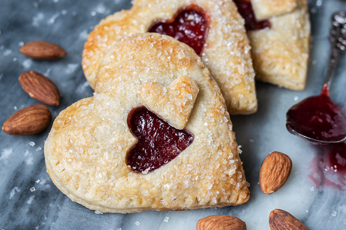 Jammy Almond Hand Pies feature nutty almond filling and fruity jam tucked inside flaky pastry dough. Shaped like hearts, they're perfect for Valentine's Day!